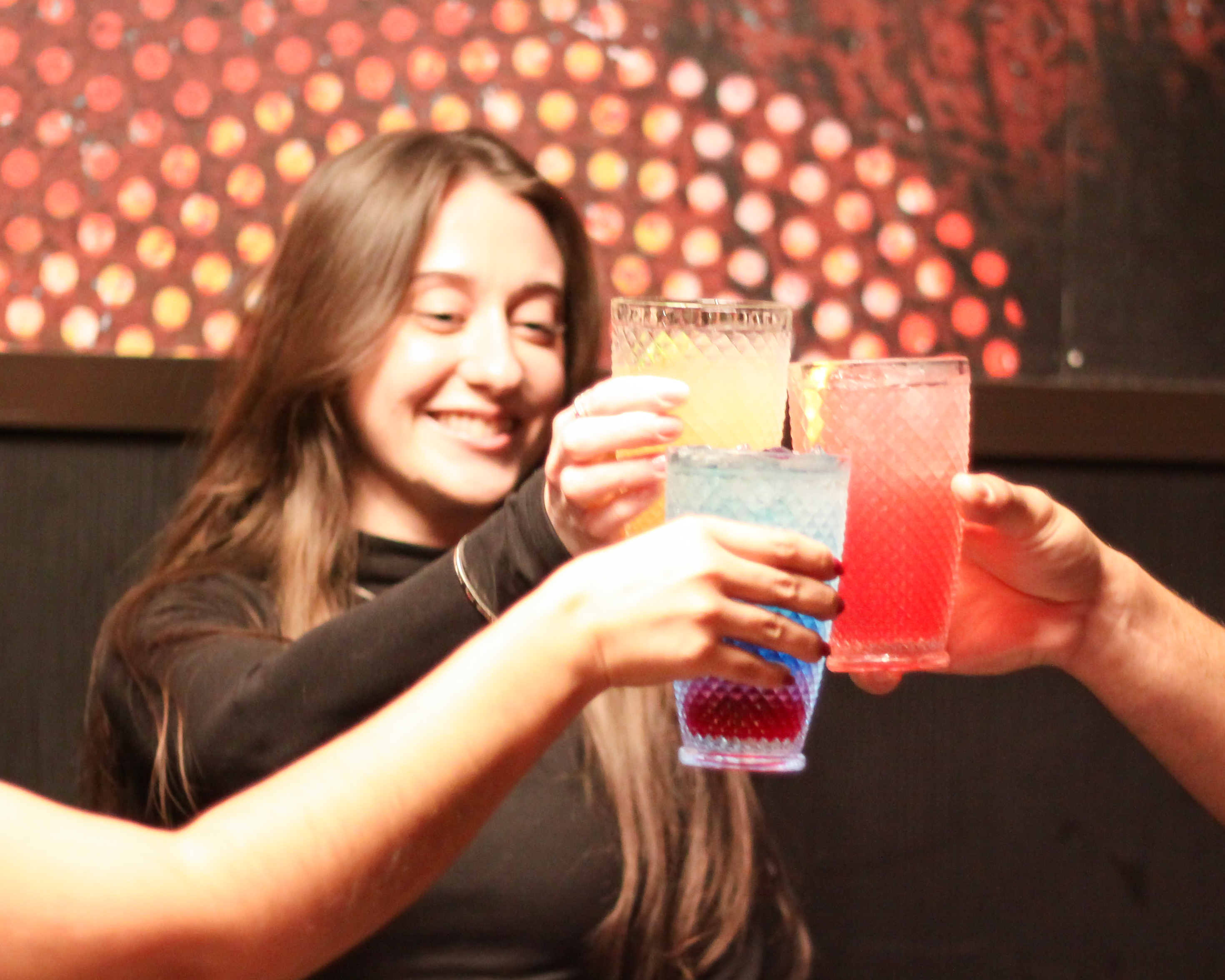 Woman holding Saga V mocktail with friends.